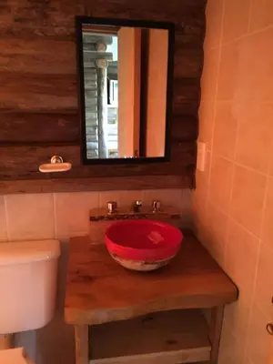 a bathroom with a red sink and a mirror at Enkel Cabañas in José de la Quintana