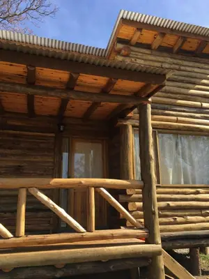 a log cabin with a porch and a window at Enkel Cabañas in José de la Quintana