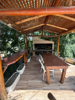 a wooden deck with a table and a piano at Departamento frente al rio solo familias in Villa Carlos Paz