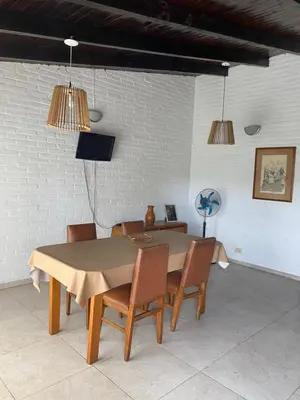 a dining room with a table and chairs at Departamento frente al rio solo familias in Villa Carlos Paz