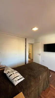 a bedroom with a large bed and a flat screen tv at Departamento en Guemes in Cordoba