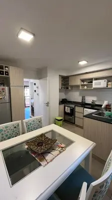 a kitchen with a white table and chairs and a kitchen with a counter at Departamento en Guemes in Cordoba