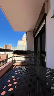 a balcony with a table and chairs on a building at Departamento en Guemes in Cordoba