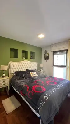 a large bed in a bedroom with green walls at Departamento en Guemes in Cordoba