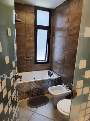 a bathroom with a tub and a toilet and a sink at Amplio departamento frente al lago-seguridad 24hs in Villa Carlos Paz