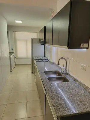 a kitchen with a sink and a counter top at Amplio departamento frente al lago-seguridad 24hs in Villa Carlos Paz