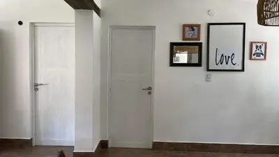 a hallway with two white doors and pictures on the wall at Casa calma in Villa de Las Rosas