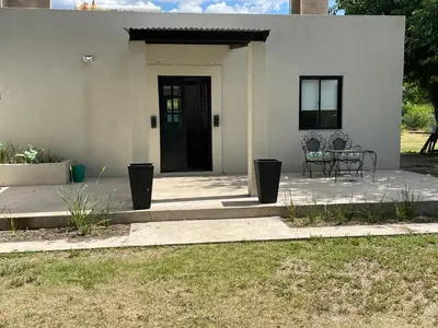 a white house with a table and chairs on a patio at Casa calma in Villa de Las Rosas