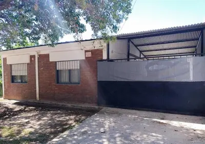 a brick building with a black and white fence at La Casa De Juan in Mina Clavero