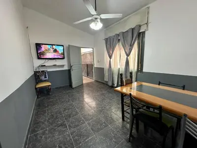 a dining room with a table and a flat screen tv at La Casa De Juan in Mina Clavero