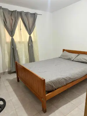 a wooden bed in a room with curtains at La Casa De Juan in Mina Clavero