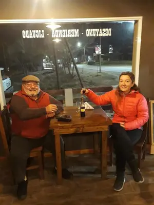 a man and a woman sitting at a table at Posada Villa Yacanto in Villa Yacanto