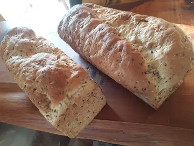 two loaves of bread sitting on a wooden cutting board at Posada Villa Yacanto in Villa Yacanto