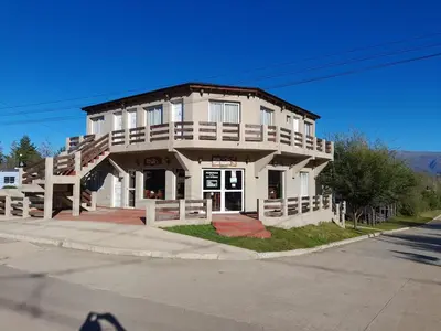 a large white building on the corner of a street at Posada Villa Yacanto in Villa Yacanto