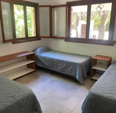 a bedroom with two beds and two windows at Chalet Fratelli Rigoni in Villa Ciudad Parque