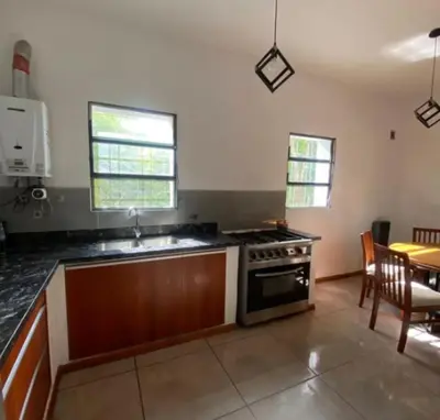a kitchen with a stove and a dining room at Chalet Fratelli Rigoni in Villa Ciudad Parque