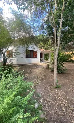a white house with a tree in front of it at Chalet Fratelli Rigoni in Villa Ciudad Parque