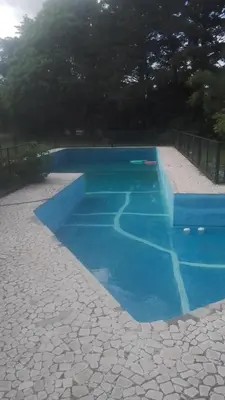 a swimming pool with blue water in a yard at Portal de las Sierras in Bialet Massé