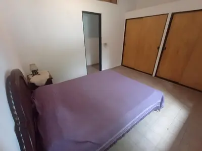 a bedroom with a bed with purple sheets and wooden doors at Portal de las Sierras in Bialet Massé