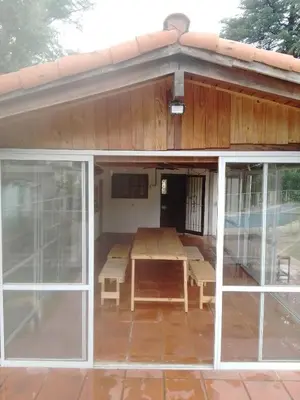 a pavilion with a table and glass doors at Portal de las Sierras in Bialet Massé
