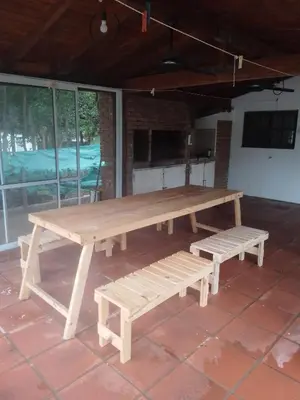 a wooden picnic table and benches on a patio at Portal de las Sierras in Bialet Massé