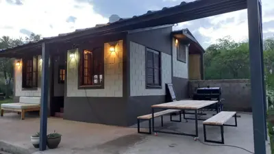 a small house with a picnic table in front of it at La Cabaña de EMI in La Bolsa