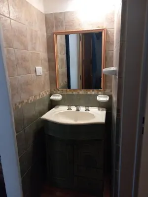 a bathroom with a sink and a mirror at La Cabaña de EMI in La Bolsa