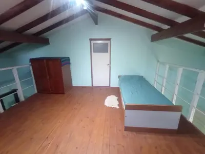 a room with a bed and a wooden floor at Portal de las sierras in Bialet Massé