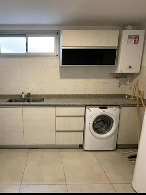 a kitchen with a washing machine and a microwave at DEPARTAMENTO Villa Carlos Paz altos de Lincoln in Villa Carlos Paz