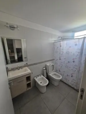 a bathroom with a sink and a toilet and a shower curtain at DEPARTAMENTO Villa Carlos Paz altos de Lincoln in Villa Carlos Paz