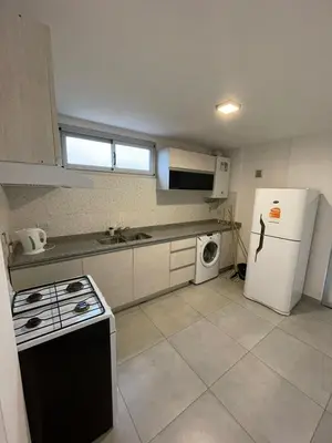 a kitchen with a white refrigerator and a dishwasher at DEPARTAMENTO Villa Carlos Paz altos de Lincoln in Villa Carlos Paz