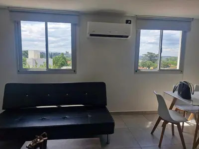 a living room with a couch and two windows at DEPARTAMENTO Villa Carlos Paz altos de Lincoln in Villa Carlos Paz