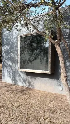 a window on the side of a building next to a tree at Las Lomitas in Carpintería