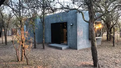 a blue building in the middle of a forest at Las Lomitas in Carpintería