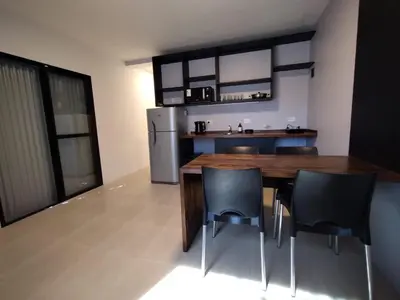 a kitchen with a table and chairs and a refrigerator at Las Lomitas in Carpintería