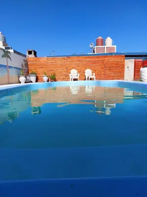 two white chairs sitting in a swimming pool at Cabañas los materos 2 in Cordoba