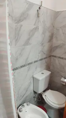 a bathroom with a white toilet and a sink at Cabañas los materos 2 in Cordoba