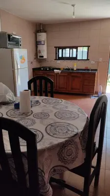 a kitchen with a table and a refrigerator at Cabañas los materos 2 in Cordoba
