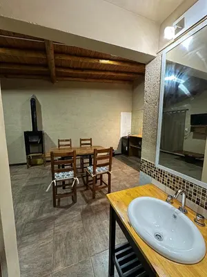 a bathroom with a sink and a table and chairs at Cabañas misueño in Villa Ciudad de America