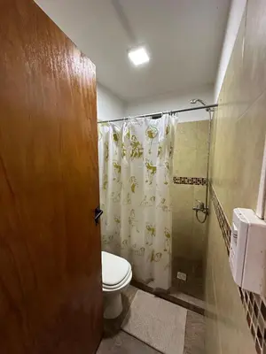 a bathroom with a toilet and a shower at Cabañas misueño in Villa Ciudad de America