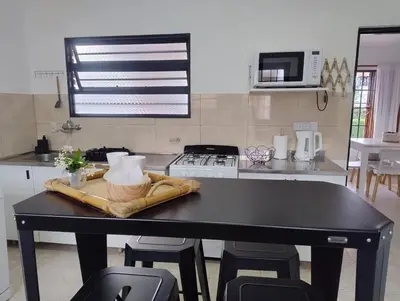 a kitchen with a black table with chairs and a stove at Casa con pileta cómoda y equipada in Villa Carlos Paz