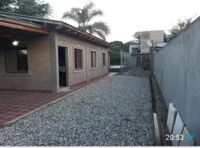 an empty street next to a house with a building at Casa El Aromito Anisacate in Villa Anizacate