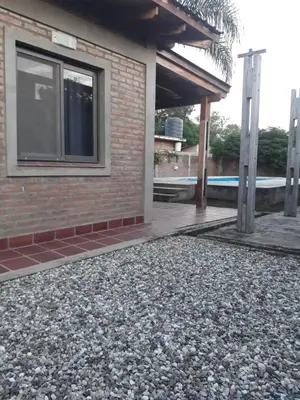 a house with a large pile of gravel next to a building at Casa El Aromito Anisacate in Villa Anizacate