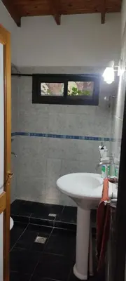 a bathroom with a white sink and a window at Casa El Aromito Anisacate in Villa Anizacate