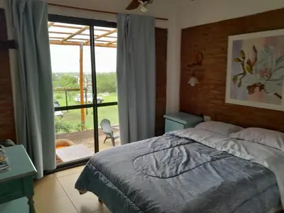 a bedroom with a bed and a view of a patio at Alquiler temporario tanti in Villa Carlos Paz