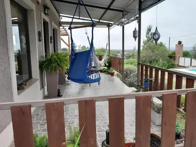 a porch with a blue hammock on a house at Alquiler temporario tanti in Villa Carlos Paz