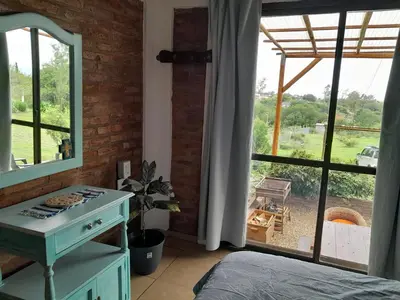 a bedroom with a bed and a large window at Alquiler temporario tanti in Villa Carlos Paz
