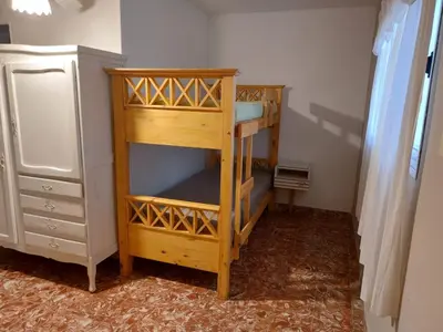 a wooden bunk bed in a room with a dresser at Mirador de estrellas in Villa Rumipal