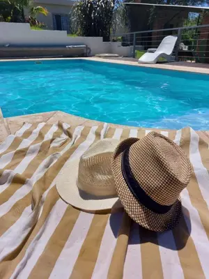 a hat sitting on a blanket next to a swimming pool at Mirador de estrellas in Villa Rumipal