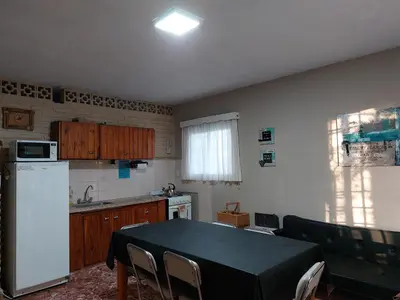a kitchen with a table and a white refrigerator at Mirador de estrellas in Villa Rumipal